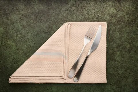 Table fork and knife lie on folded napkin, serving concept, close up with cop Stock Photos
