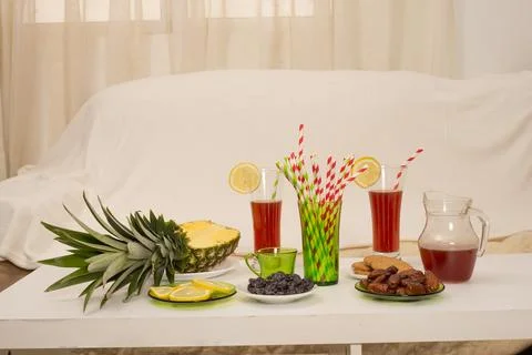 Table WITH fresh sliced pineapple, lemon wedges, dates,cookies Stock Photos