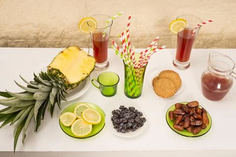 Table WITH fresh sliced pineapple, lemon wedges, dates,cookies Foto stock