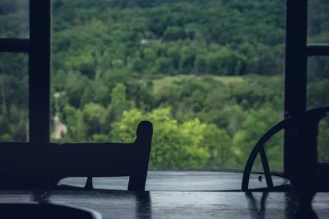 Table in front of forest filled window Stock Photos