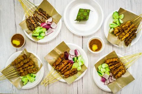 A table full of different kinds of satay and side dishes and peanut sauce Stock Photos
