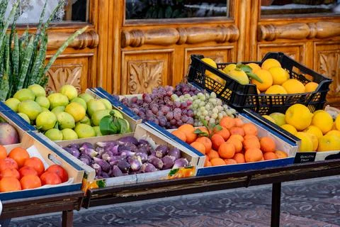 A table full of fruit including oranges, apples, and grapes Stock Photos