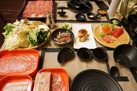 A table full of prepared plates of fresh vegetables, sliced Wagyu beef Stock Photos