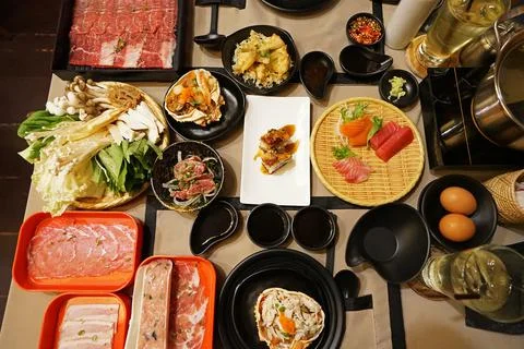A table full of prepared plates of fresh vegetables, sliced Wagyu beef Stock Photos