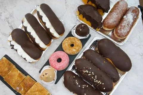A table full of various types of donuts and pastries Stock Photos