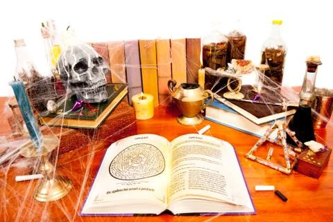 Table full of witchcraft related objects and cobwebs isolated on white Stock Photos