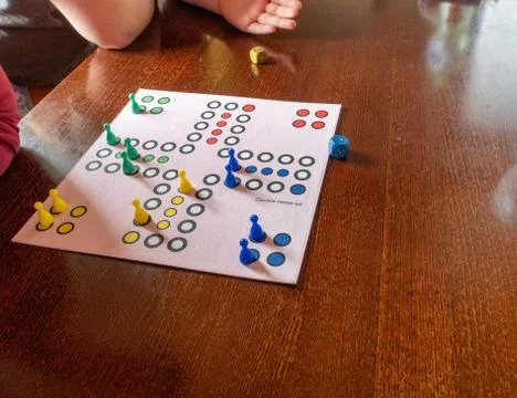 Table game. Movement, the cube flies. Girl throws a cube. Victory. Selective  Stock Photos