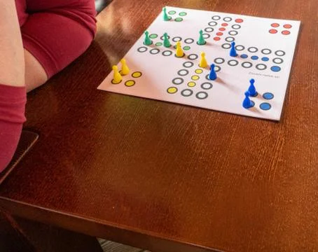 Table game. Movement, the cube flies. Girl throws a cube. Victory. Selective  Stock Photos