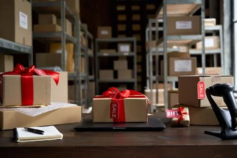 Table with gift parcel boxes on table in warehouse. Online ecommerce sale. Stock Photos