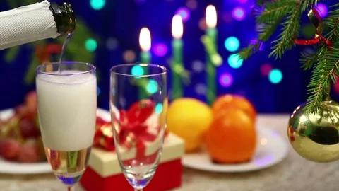 On the table with gifts the man opens the shompank and pours it into glasses 库存影片 82325233