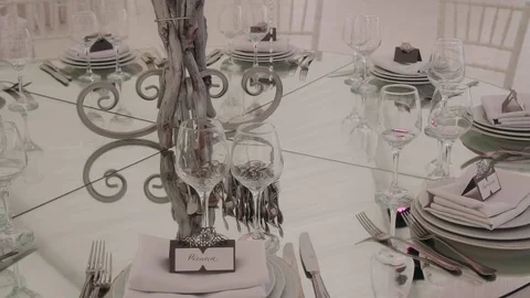 Table with glasses and plates on it.. A prepared serving table Stock Footage 129421501