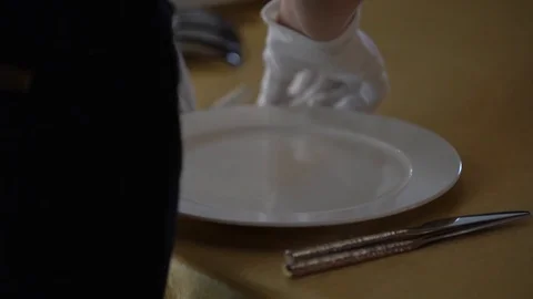 On the table with a Golden tablecloth are white plates Stock Footage 103469650