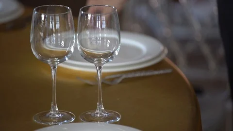On the table with a Golden tablecloth are white plates, wine glasses Stock Footage 103469714
