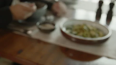 On the table is a green salad with cucumbers and man eating juice Stock Footage 161253989