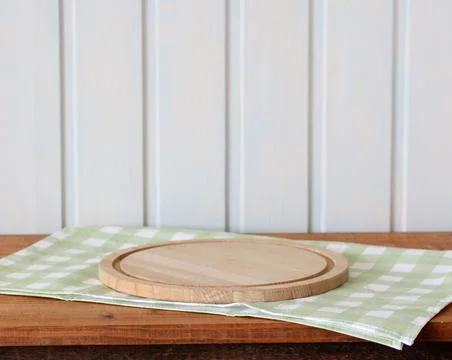 Table with a green tablecloth and a cutting board in the kitchen in a white Stock Photos