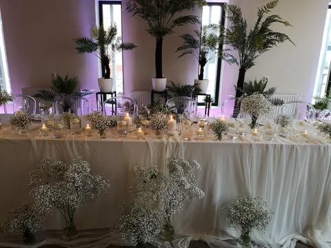 A table has many different tables covered with flowers and candles Fotos de archivo