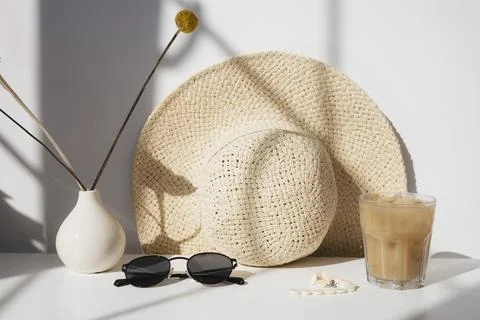 On table is hat, sunglasses and cold coffee, bright sunlight Stock Photos