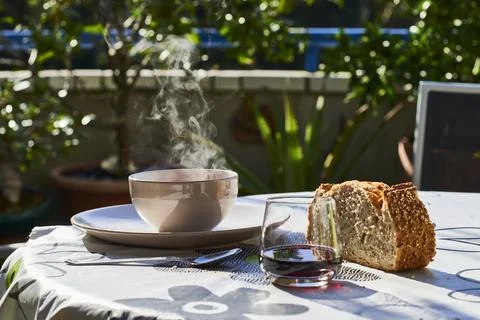 Table with hot dish of soup, bread and red wine at terrace Stock Photos