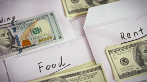 On a table in the household envelopes marked Rent Food Wedding hold banknote Stock Footage 336570103