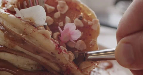 A table knife is cutting a slide of pancakes with chocolate cream dessert 스톡 동영상 151835390