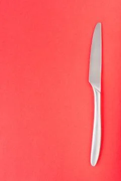Table knife on yellow background, top view Foto stock