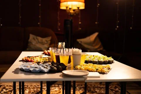 Table laden with assorted appetizers, drinks, and desserts for a party Stock Photos