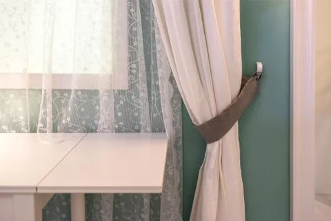 Table-lamp on bedside table against latticed window in room. Stock Photos