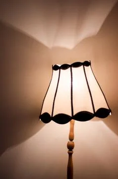 Table lamp with dramatic light pattern on wall Stock-Fotos