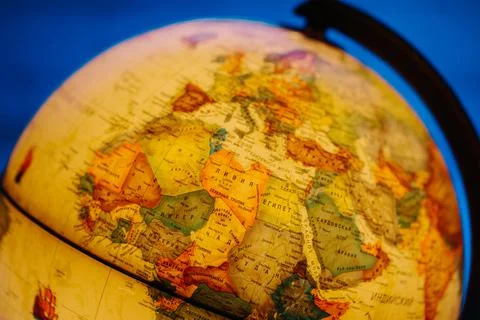 A table lamp in the form of a globe, a rotating globe of the earth on a blue Stock Photos