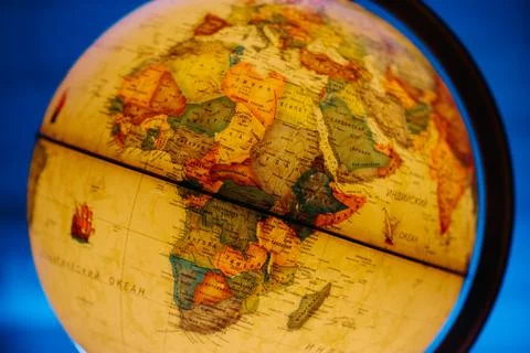 A table lamp in the form of a globe, a rotating globe of the earth on a blue Stock Photos