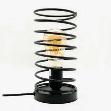 A table lamp in the shape of a shock absorber with a light bulb inside, cut o Foto stock