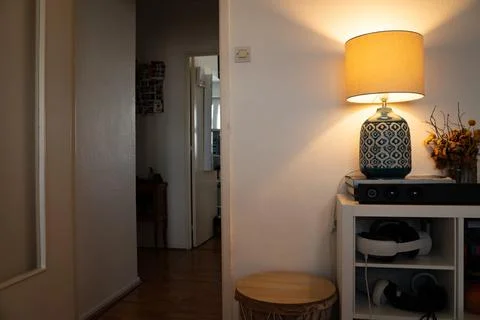 Table lamp on a shelf table in cluttered living room Stock Photos