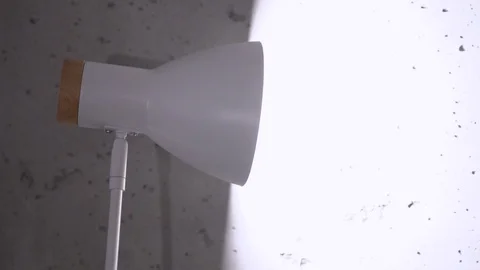 The table lamp shines with warm light on wall, loft style. Warm lighting. Stock Footage 122578668