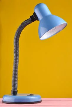 Table lamp on a table isolated against a yellow wall background.. Table lamp  库存照片