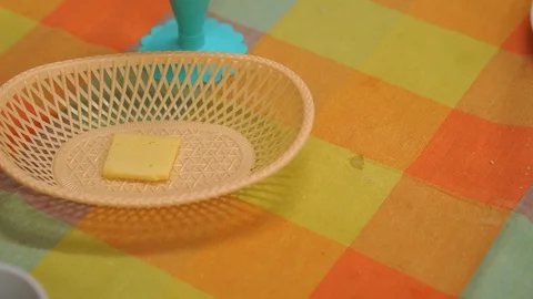 On the table is the last piece of cheese. The child wants to eat it unnoticed. Stock Footage 100357573