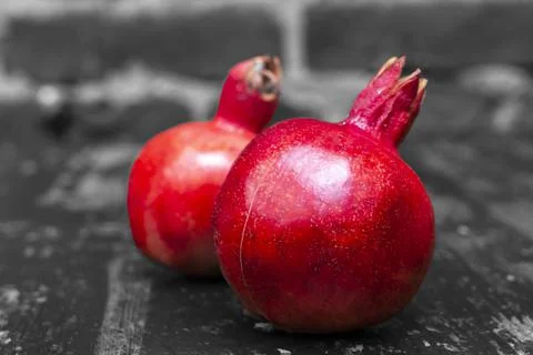 On the table lay two red pomegranate. Two ripe garnet on the table on black a Foto stock
