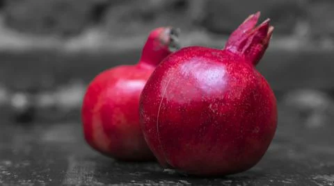 On the table lay two red pomegranate. Two ripe garnet on the table on black a Foto stock
