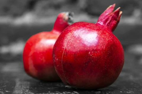 On the table lay two red pomegranate. Two ripe garnet on the table on black a Foto stock