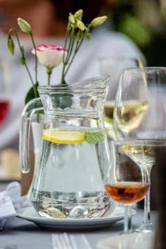 Table laying concept. On the table stands a jug with water and lemon. Glasses Stock Photos