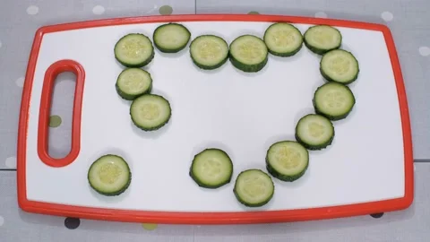 On the table lined with a heart of cucumbers. The pieces begin to move and line Vídeo Stock 102607274