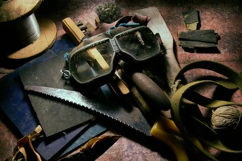 The table is littered with a bunch of old things, construction tools, objects Stock Photos