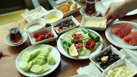 Table with lots of dishes and small plates, waiter puts more plates on table Stock Footage 235418367