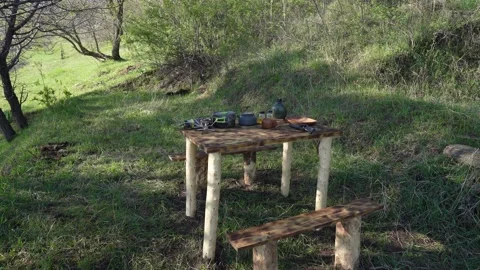A table made of wood against the background of plants of trees and grass, a Stock Footage 242864097
