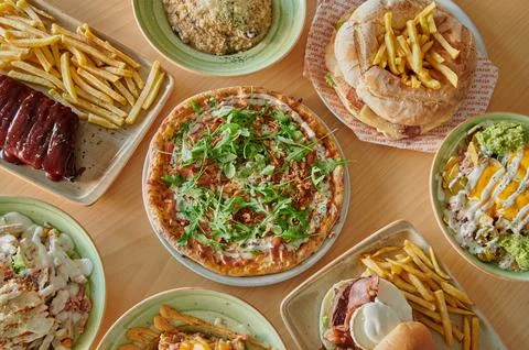 A table with many different types of food, including pizza, sandwiches Stock Photos