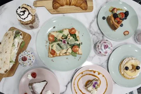A table with many different types of food, including a cake, a sandwich Stock Photos