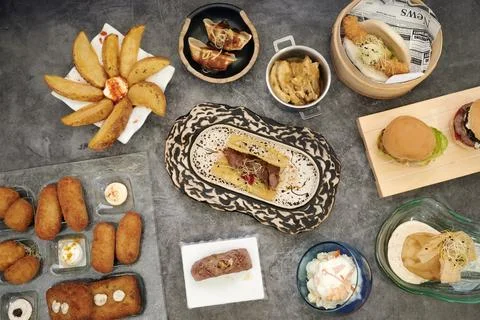 A table with many different types of food, including a sandwich, a bowl of salad Stock Photos