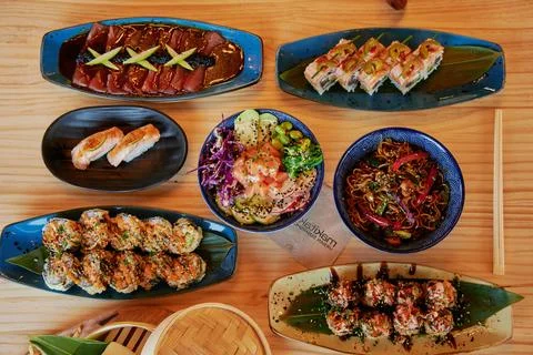 A table with many different types of food, including sushi Stock Photos