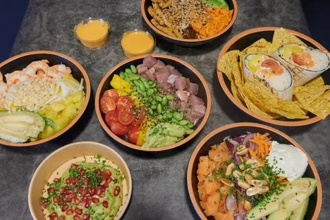 A table with many different types of sushi and other Asian food Stock Photos