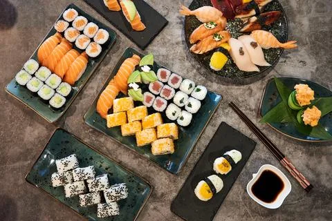 A table with many different types of sushi and chopsticks Stock Photos