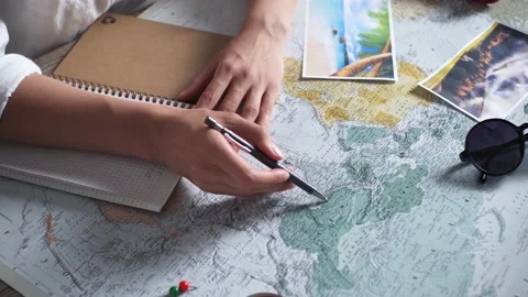 A table with a map on it. A woman makes a travel itinerary. Traveler with tr Stock Footage 201754343